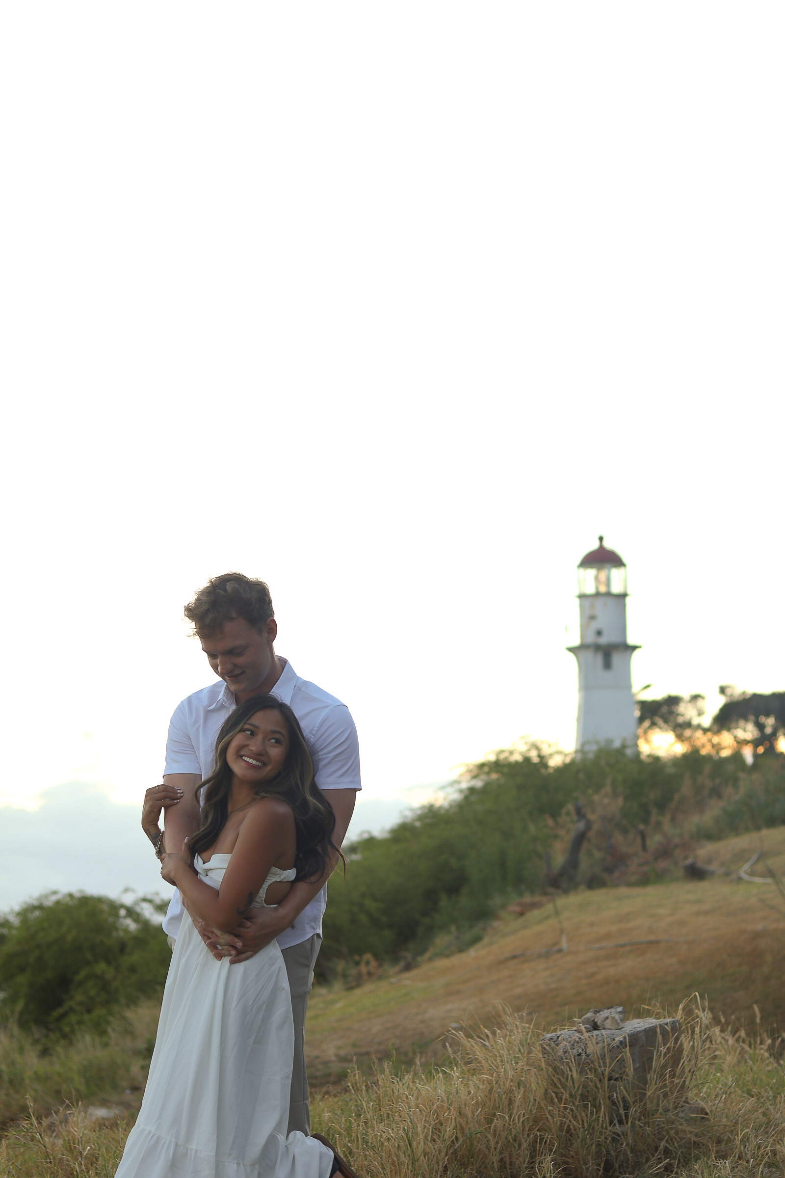 Couple kissing against rocky cliff face by the beach
